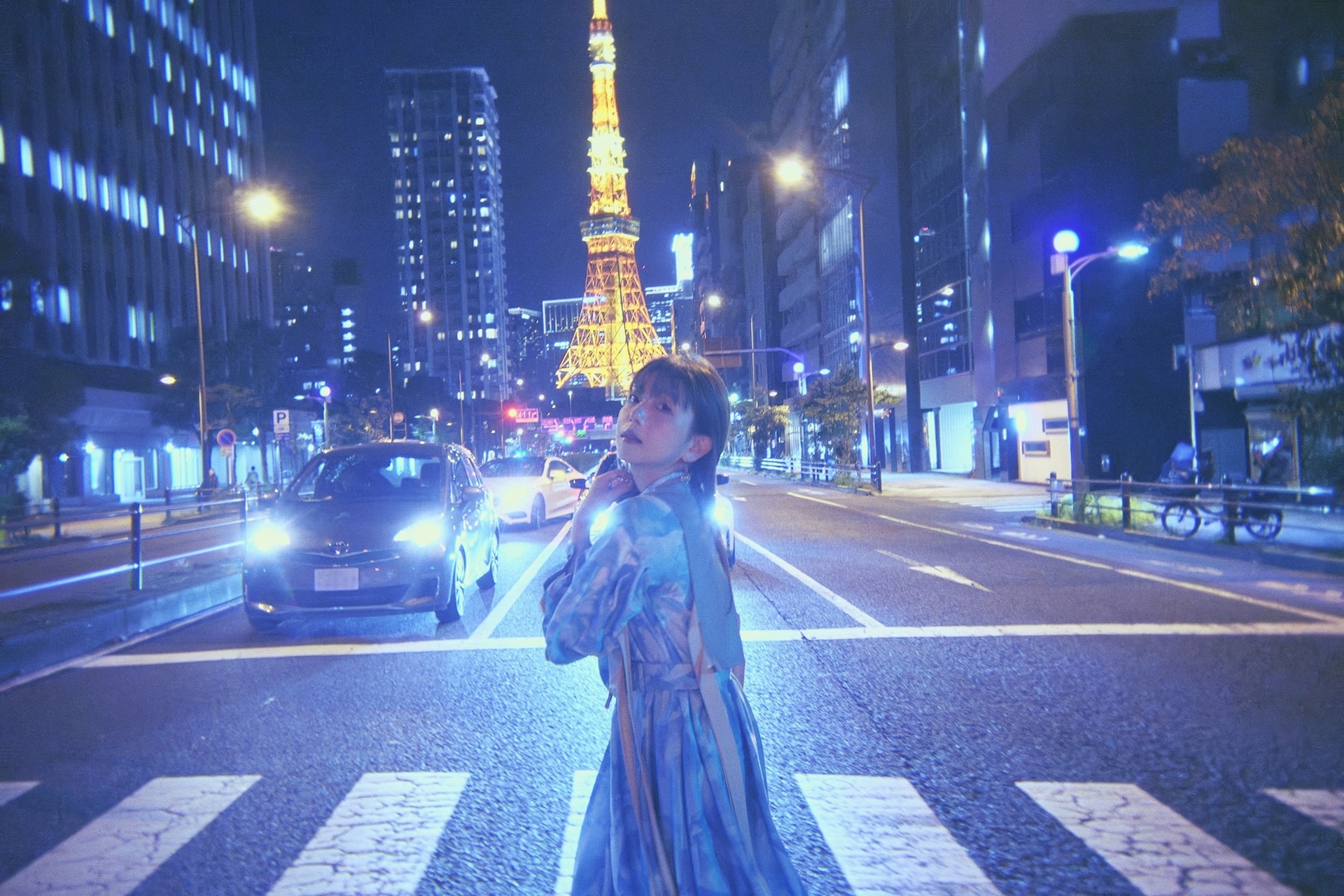 Yui Makino em uma rua de Tóquio à noite, com a Torre de Tóquio ao fundo