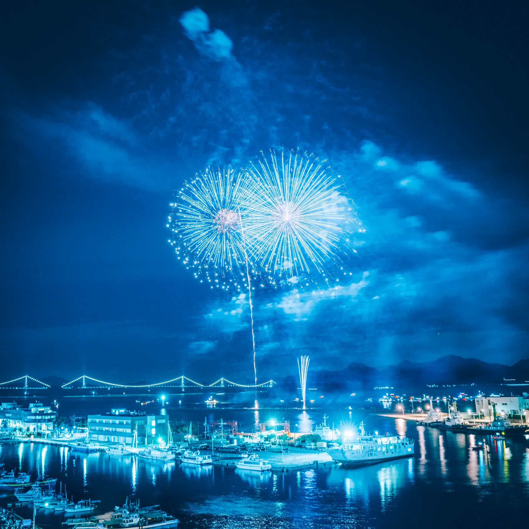 Capa do single Yuuzutsu com fogos de artifício sobre uma cidade à noite
